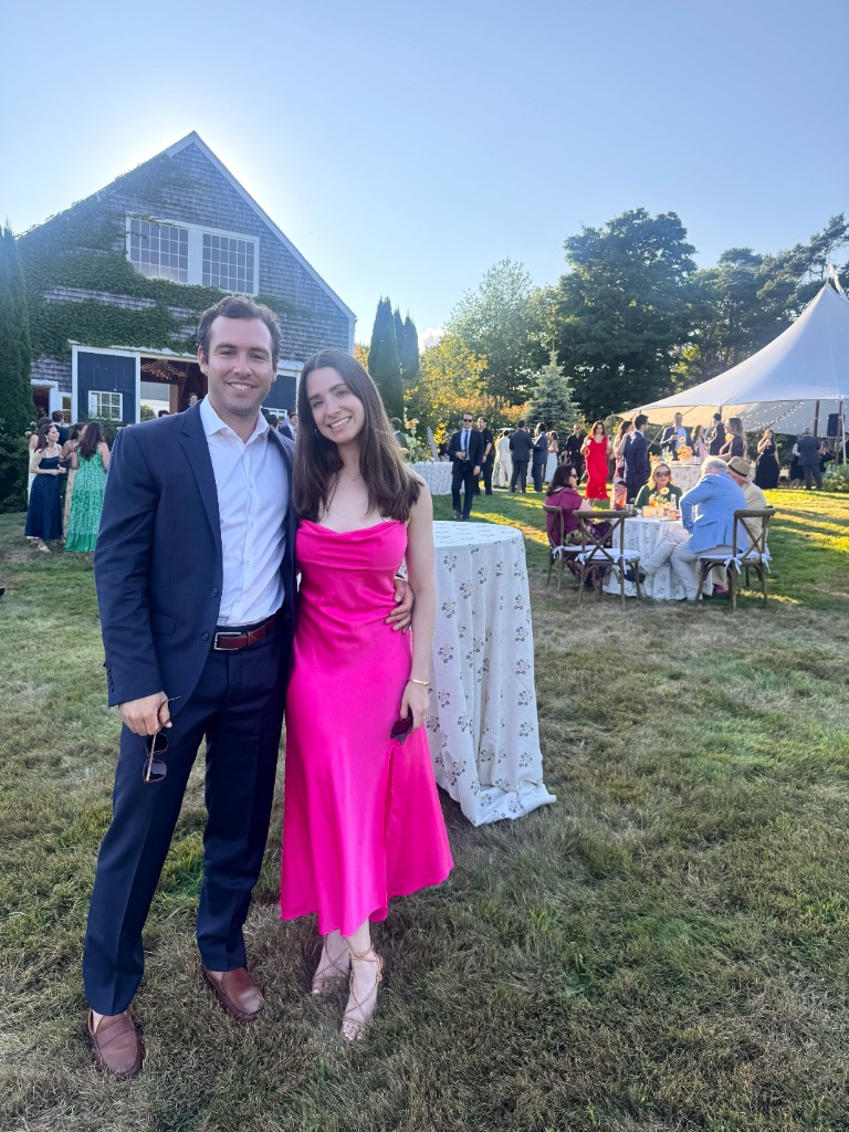 Jenna and Wyatt at an outdoor gathering, Jenna in a pink dress and Wyatt in a navy suit