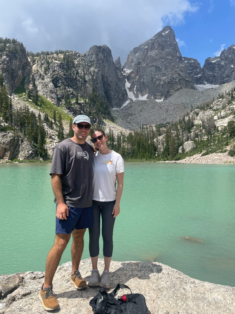 Jenna and Wyatt on a rock above a turquoise alpine lake