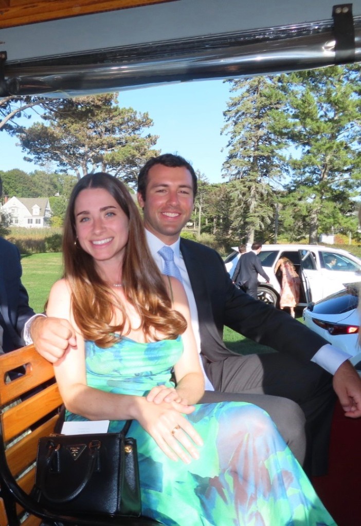 Jenna and Wyatt seated together on a shuttle, smiling